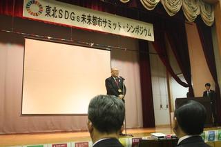 シンポジウムで秋田県仙北市門脇市長が挨拶する画像